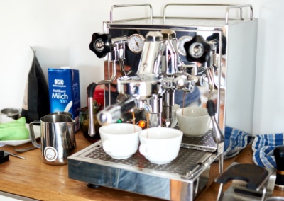 Espressomaschine mit Milchkännchen und Tassen, aufgebaut für das Training in der eigenen Küche