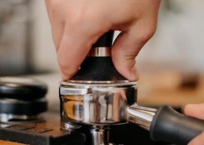 Kaffeemehl wird im Siebträger mit dem Tamper angedrückt