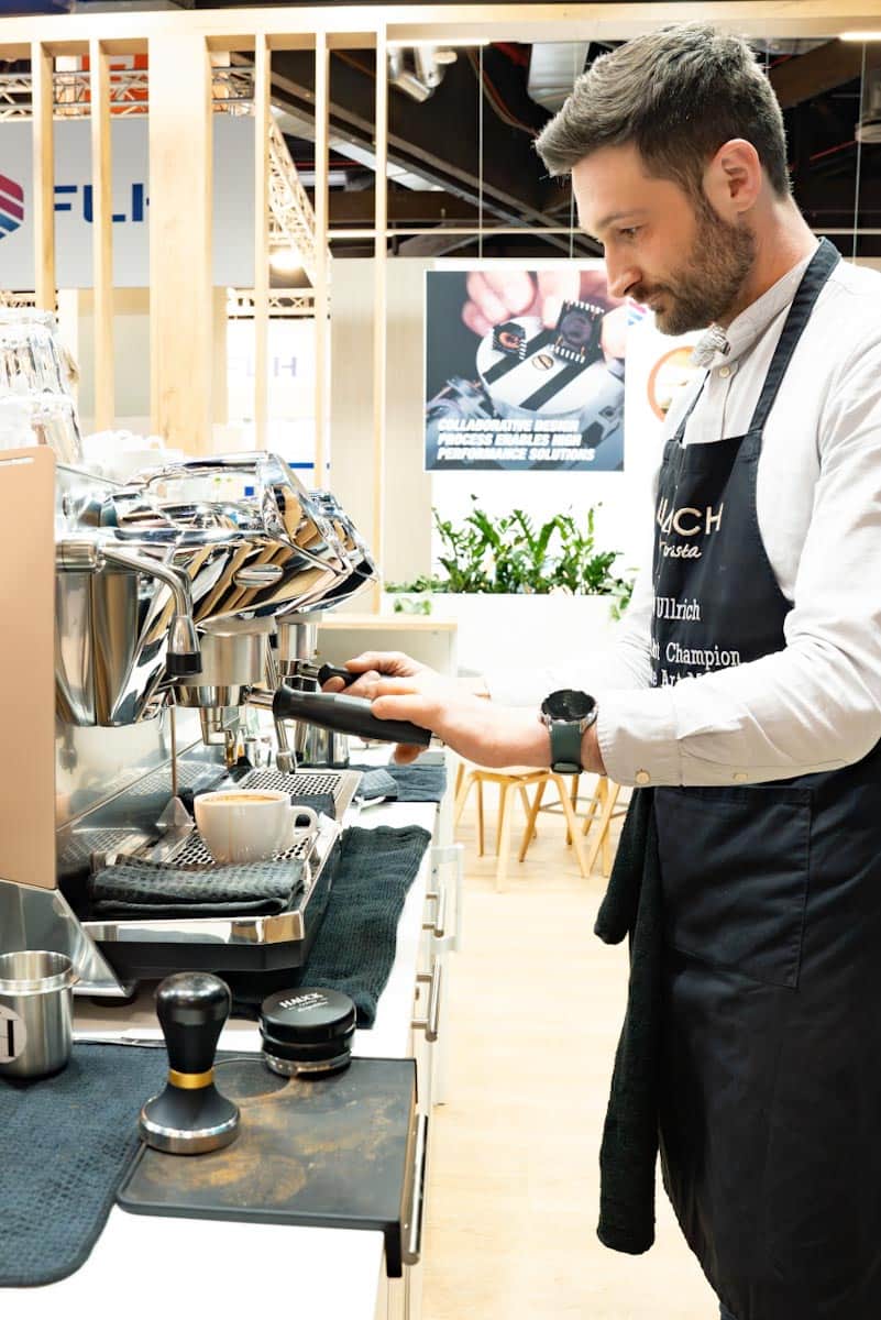 barista-an-der-siebtraegermaschine-messestand.jpg Christian Ullrich bezieht einen Espresso an der Siebträgermaschine der mobilen Kaffeebar am Messestand